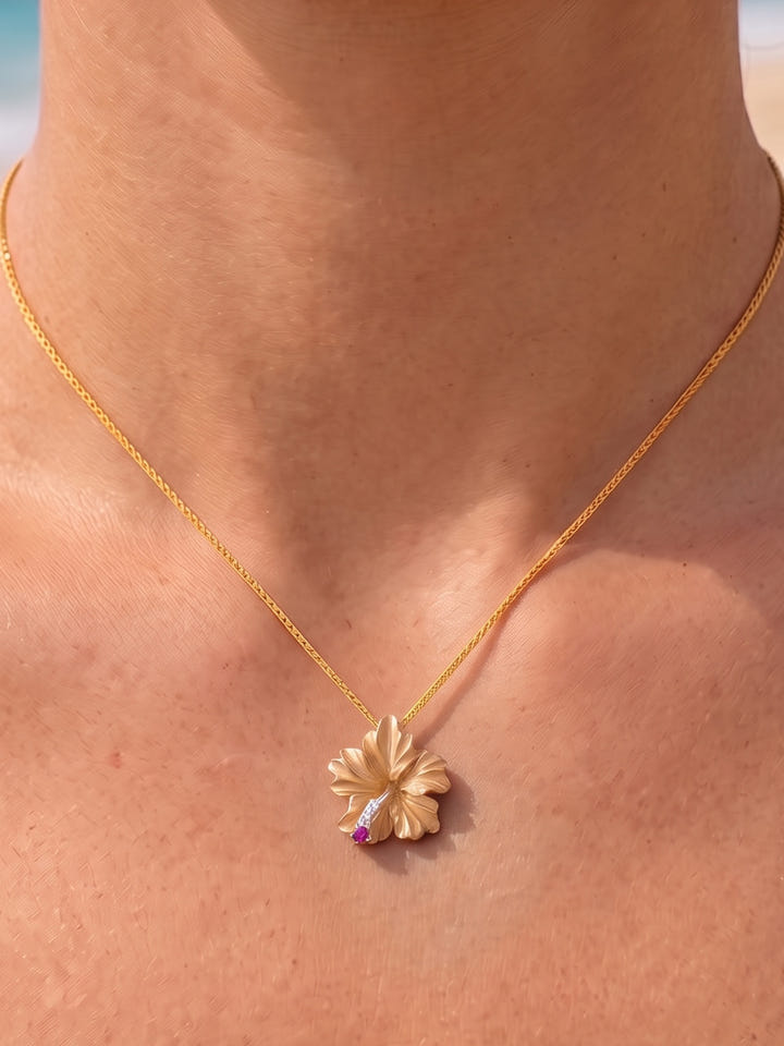 14k Hibiscus Pendant with 3 diamonds and ruby — close-up on model
