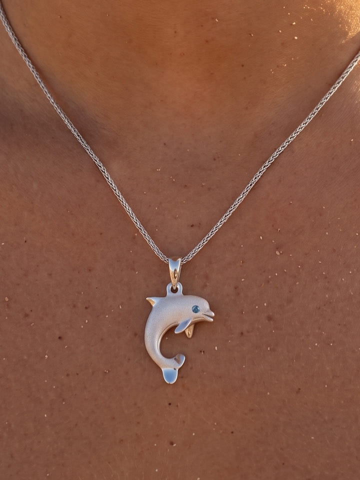 14k 20mm "Jumping Single" Dolphin Pendant with 0.01 carat blue diamond — close-up on model