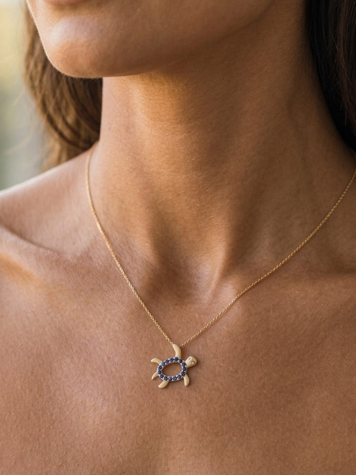 14k 2/tone 12mm "Hawaiian Petroglyph" Honu Pendant with 2 Diamonds and 15 Blue Sapphires — close-up on model