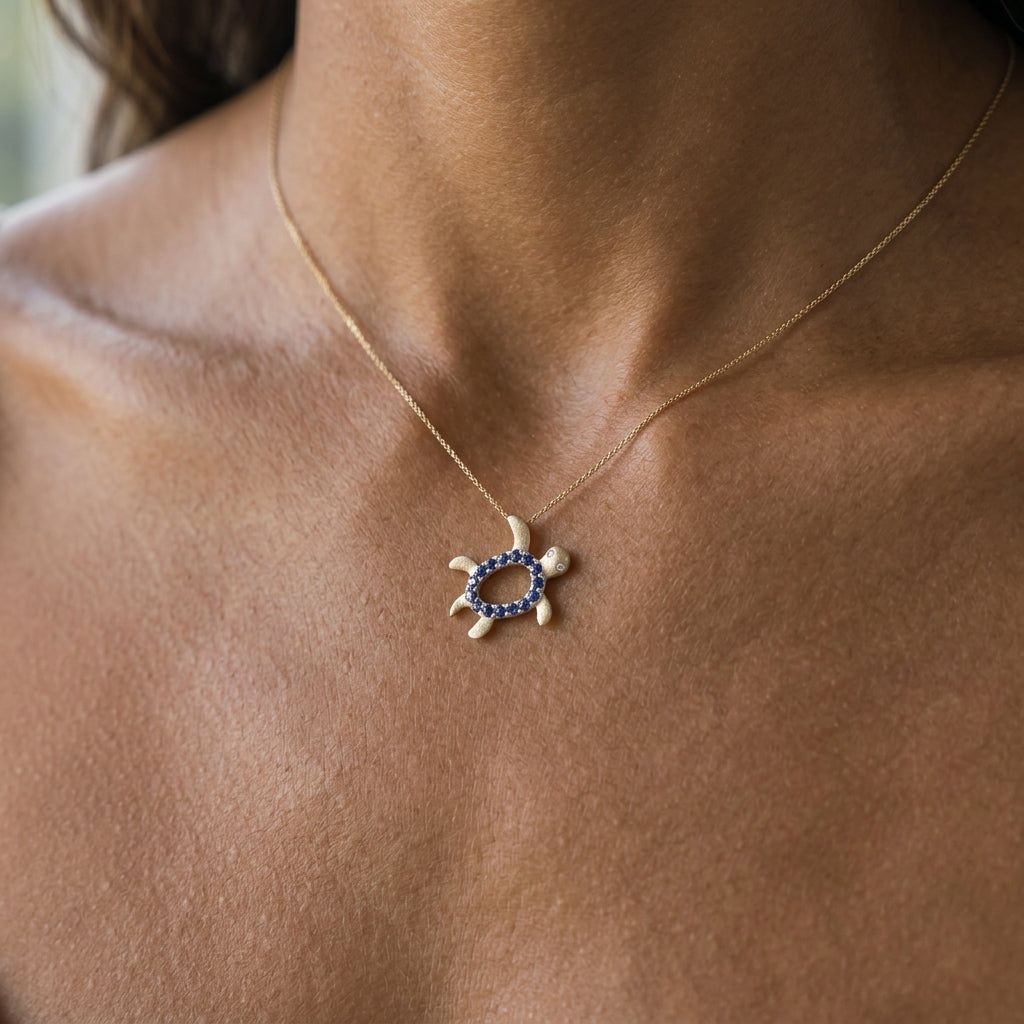 14k 2/tone 12mm "Hawaiian Petroglyph" Honu Pendant with 2 Diamonds and 15 Blue Sapphires — worn on model (brunette, view 2)