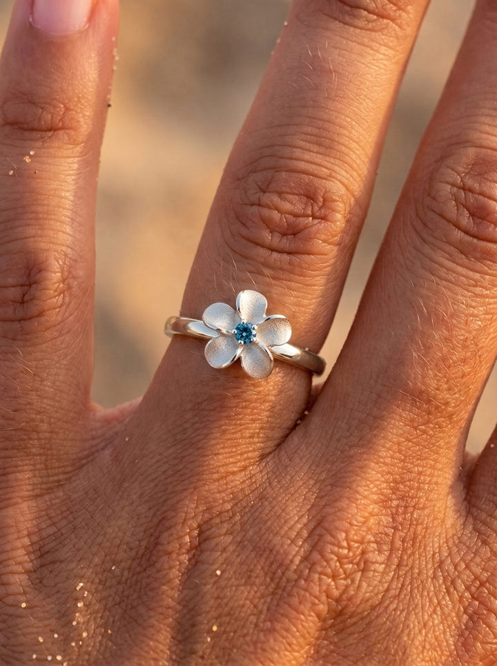 14k 10mm Plumeria Ring with blue diamond — close-up on model