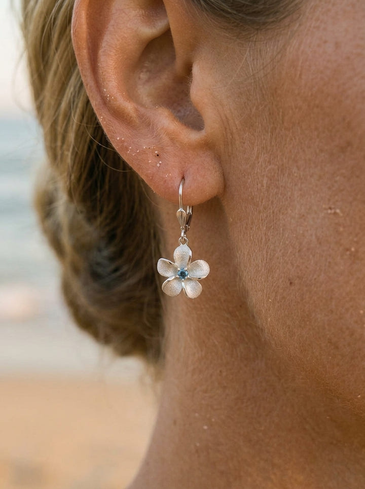 14kw 8mm Plumeria Earrings with 2 blue diamonds — close-up on model
