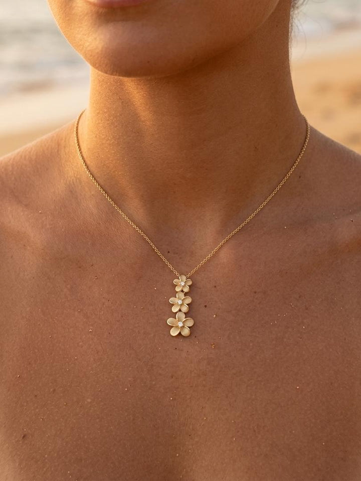 14k 6, 8 & 10mm Plumeria Lei Slide Pendant with 3 diamonds — close-up on model
