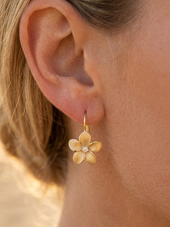 14k 15mm Plumeria Earring with 2 Diamonds — close-up on model