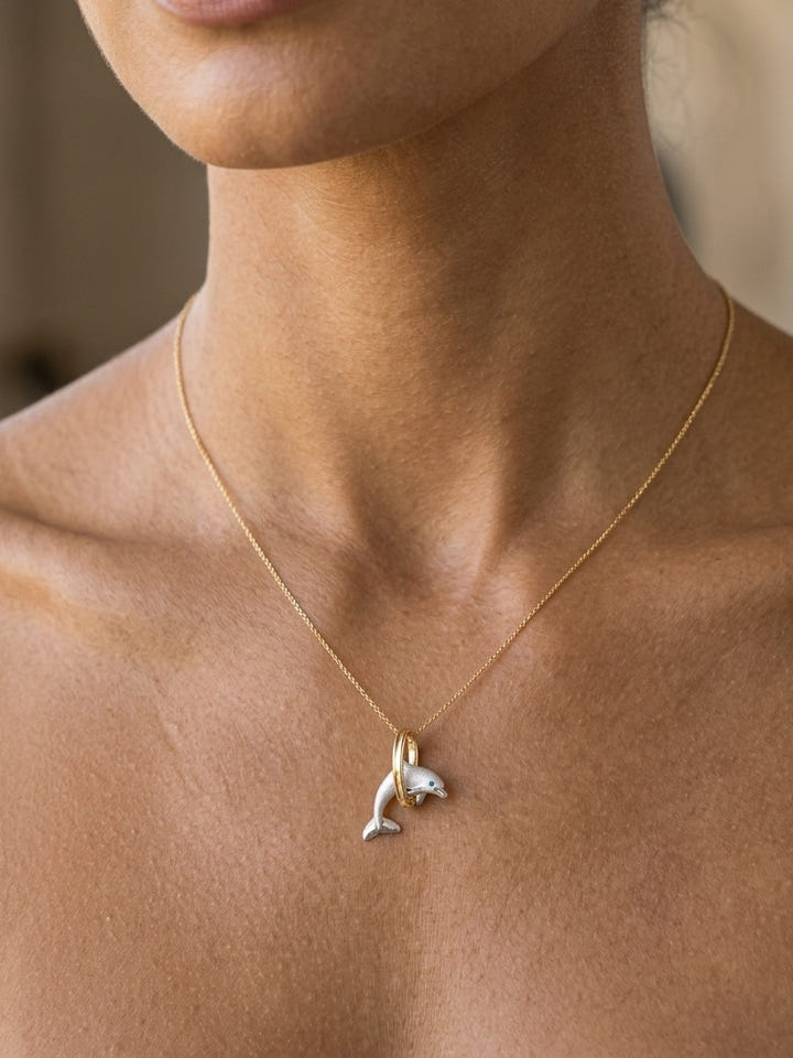 14k 2/tone 20mm "Jumping Loop" Dolphin Pendant with blue diamond — close-up on model