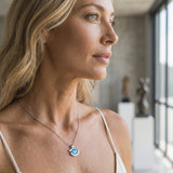 14K Small White Gold Wave Pendant with Diamond — worn on model (blonde, macro close-up)