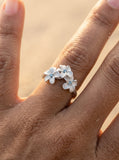 8mm 14k Plumeria Ring with 3 blue diamonds — studio macro closeup on model (brunette)