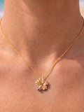 14k Hibiscus Pendant with 3 diamonds and ruby — close-up on model