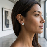 14kw/g 11mm Plumeria Earrings with 2 blue diamonds — worn on model (brunette, view 1)