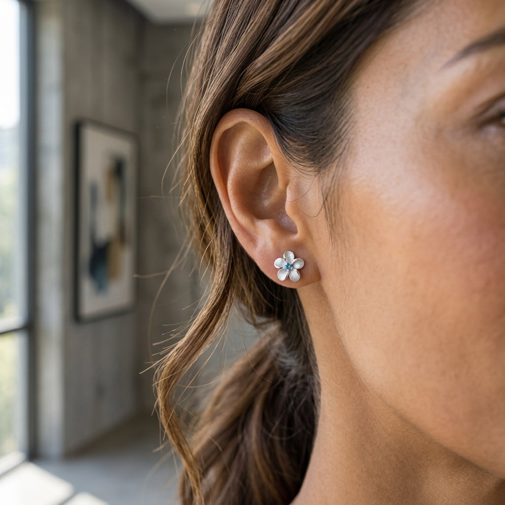 8mm 14k Plumeria Earring with 2 blue diamonds — worn on model (brunette, view 2)