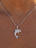 14k 20mm "Jumping Single" Dolphin Pendant with 0.01 carat blue diamond — close-up on model
