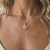 14K Yellow Gold Firefly Pendant — worn on model (blonde, macro close-up)