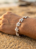 14k 11mm Plumeria Bracelet 7" with 13 diamonds and 13pc flowers — close-up on model