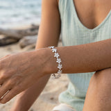 14k 11mm Plumeria Bracelet 7" with 13 diamonds and 13pc flowers — worn on model (brunette, view 3)