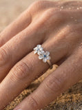 14k White Gold 8mm Plumeria Ring with 3 blue diamonds — close-up on model
