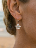 14kw 8mm Plumeria Earrings with 2 blue diamonds — close-up on model