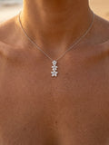 6, 8 & 10mm 14k Plumeria Lei Slide Pendant with 3 blue diamonds — close-up on model
