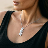 14k Plumeria Lei Slide Pendant with blue diamonds — worn on model (brunette, view 3)