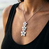 14k Plumeria Lei Slide Pendant with blue diamonds — worn on model (brunette, view 4)