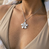 14k 15mm White Gold Plumeria Pendant — worn on model (brunette, view 4)