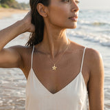 13mm 14k Plumeria Pendant with 0.03 carat diamond — worn on model (brunette, view 1)
