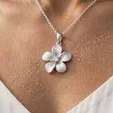 13mm 14k Plumeria Pendant with 0.03 carat diamond — worn on model (brunette, view 4)