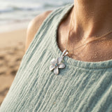 13mm 14k Plumeria Pendant with 0.03 carats blue diamond — worn on model (brunette, view 4)