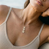 14k Plumeria Lei Slide Pendant with 3 diamonds — worn on model (brunette, view 3)