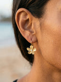14k 13mm Plumeria Earrings with 2 Diamonds — close-up on model