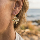 14k 11mm Plumeria Earrings Lever back with 2 diamonds — worn on model (blonde, view 4)