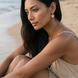 14k Rose Gold 11mm Plumeria Earrings with 2 diamonds — worn on model (brunette, view 2)