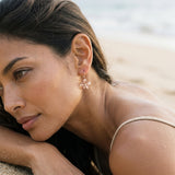 14k Rose Gold 11mm Plumeria Earrings with 2 diamonds — worn on model (brunette, view 4)