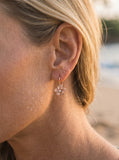 8mm 14k Plumeria Earrings with 2 diamonds — close-up on model