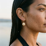 14k 12mm Sand Dollar Earrings with 20 Diamonds — worn on model (brunette, view 3)