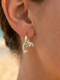 14k 15mm "Jumping Loop" Dolphin Earrings with 6 diamonds — close-up on model