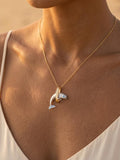 14k 2/tone 28mm "Jumping Loop" Dolphin Pendant with 2 blue diamonds — close-up on model