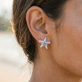 Precious Silver 18mm Starfish Earrings with 32 Blue Sapphires — worn on model (brunette, view 4)