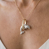 14k 15mm "Jumping Loop" Dolphin Pendant with 0.01 Blue Diamond — worn on model (blonde, view 2)