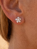 8mm Plumeria Earrings 14k with 2 diamonds — close-up on model