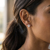 8mm Plumeria Earrings 14k with 2 diamonds — worn on model (brunette, view 1)