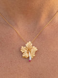 14k 28mm Hibiscus Pendant with 6 diamonds and ruby — close-up on model